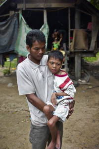 A fourteen-year old boy and his father at their home in the Central Highlands of Vietnam. This boy and his younger brother are victims of dioxin poisoning. Photo taken by Morgan Ommer.