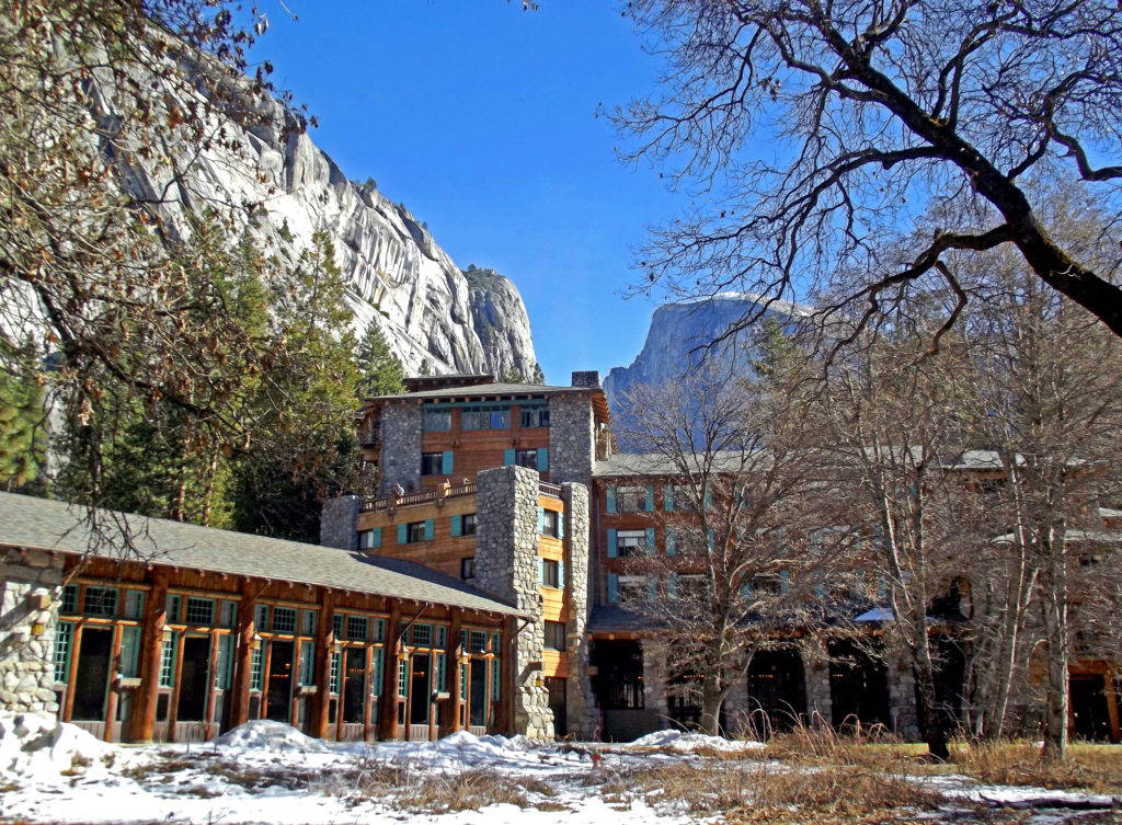 The Ahwanhee Hotel in Yosemite National Park, with the iconic peaks of Half Dome in the background. Photo credit: Creative Commons.