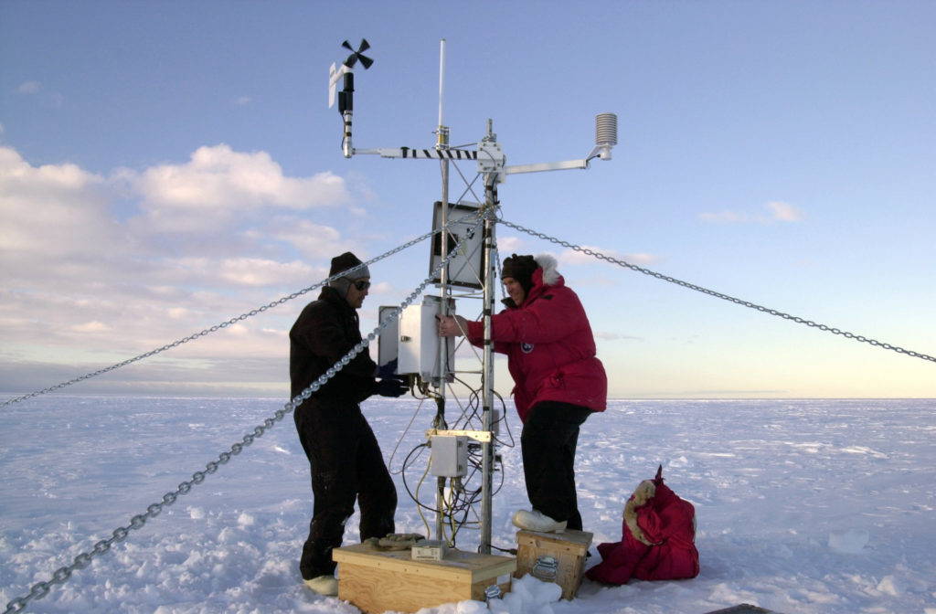 Scientists set up equipment on an iceberg to measure climate change. Public domain.