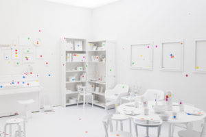 In Obliteration Room, Yayoi Kusama invites her audience at the Helsinki Arm Museum to cover a room with brightly colored dots. Image from Wikimedia Commons, 2017.