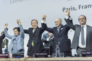 Closing ceremony of COP21, featuring Christiana Figueres (left), Executive Secretary of the UN Framework Convention on Climate Change and Secretary-General Ban Ki-moon (second from left) after the adoption of Paris Agreement on Climate Change. UN Photo, 2015.