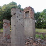 The only remaining feature of the original mansion—a single fireplace—sits atop ten-foot brick pillars installed in 1922, which narrowly managed to save the house in the 1927 flood. The tallest tree in the background is one of a pair of pines that former Mississippi Governor Dennis Murphree described in 1947 as “the only pine trees I have seen in the Mississippi Delta” and he supposed that they were planted by Yankees during the Union occupation. (Hamilton, 2014) The only remaining feature of the original mansion—a single fireplace—sits atop ten-foot brick pillars installed in 1922, which narrowly managed to save the house in the 1927 flood. The tallest tree in the background is one of a pair of pines that former Mississippi Governor Dennis Murphree described in 1947 as “the only pine trees I have seen in the Mississippi Delta” and he supposed that they were planted by Yankees during the Union occupation. (Hamilton, 2014)