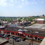 A view of Ivy City to the southwest, taken from the fifth floor of the Hecht Company Warehouse. Residences, some of which date to the late nineteenth century, are visible in the foreground. The boarded brick building to the right is the Alexander Crummell School, a beloved neighborhood school built in 1911 for African American children. Despite the local and national recognition of its historical significance, the school has been empty and deteriorating since the 1970s due to lack of funds. The domes of the U.S. Capitol and Library of Congress are visible in the background. (Rebecca Summer, 2014) A view of Ivy City to the southwest, taken from the fifth floor of the Hecht Company Warehouse. Residences, some of which date to the late nineteenth century, are visible in the foreground. The boarded brick building to the right is the Alexander Crummell School, a beloved neighborhood school built in 1911 for African American children. Despite the local and national recognition of its historical significance, the school has been empty and deteriorating since the 1970s due to lack of funds. The domes of the U.S. Capitol and Library of Congress are visible in the background. (Rebecca Summer, 2014)