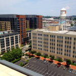 A view of the heart of NOMA (North of Massachusetts Avenue), a recently rebranded and redeveloped neighborhood in northeast DC, near Ivy City. The photograph is taken from the rooftop pool area of a new luxury apartment building, almost identical to the one seen in the left of this photograph and to several others on nearby blocks. The building to the right is the former Woodward & Lothrop department store warehouse. It was built within a year of the Hecht Company Warehouse by the same architects to serve the same functions. The building is now the icon and centerpiece of NOMA. (Rebecca Summer, 2014) A view of the heart of NOMA (North of Massachusetts Avenue), a recently rebranded and redeveloped neighborhood in northeast DC, near Ivy City. The photograph is taken from the rooftop pool area of a new luxury apartment building, almost identical to the one seen in the left of this photograph and to several others on nearby blocks. The building to the right is the former Woodward & Lothrop department store warehouse. It was built within a year of the Hecht Company Warehouse by the same architects to serve the same functions. The building is now the icon and centerpiece of NOMA. (Rebecca Summer, 2014)