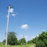 A row of utility poles, stripped bare of wires, towers above an old rail bed adjacent to the Group 63 bunker field at Midewin National Tallgrass Prairie. Erected in the early 1940s, these poles serve as constant reminders of the prairie’s past life as the Joliet Army Ammunition Plant. Upon its turnover to the U.S. Department of Agriculture in 1996, the former Joliet Arsenal contained some 373 ammunition bunkers, 429 buildings and structures, 78 miles of paved roads, and 105 miles of rail beds. Removing the vestiges of old Army infrastructure continues to play a significant role in the prairie restoration efforts at Midewin. Photo by Sean Thoel, 2017. A row of utility poles, stripped bare of wires, towers above an old rail bed adjacent to the Group 63 bunker field at Midewin National Tallgrass Prairie. Erected in the early 1940s, these poles serve as constant reminders of the prairie’s past life as the Joliet Army Ammunition Plant. Upon its turnover to the U.S. Department of Agriculture in 1996, the former Joliet Arsenal contained some 373 ammunition bunkers, 429 buildings and structures, 78 miles of paved roads, and 105 miles of rail beds. Removing the vestiges of old Army infrastructure continues to play a significant role in the prairie restoration efforts at Midewin. Photo by Sean Thoel, 2017.