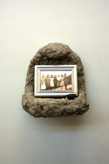 Shrine by J. Leigh Garcia. A small, concrete, wall-mounted shrine with a sepia-tone family photo inside it.