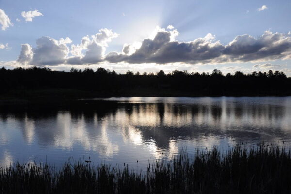 Evening sun and clouds are reflected on the surface of Manitou Lake near Woodland Park, Colorado. Evening sun and clouds are reflected on the surface of Manitou Lake near Woodland Park, Colorado.