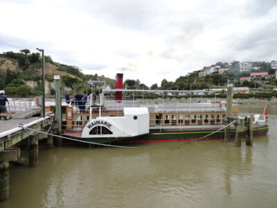 A restored paddleboat steamer, the Waimarie, takes tourists on a short scenic journey along the river. A small boat, docked
