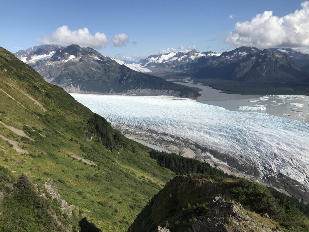 La', Eyak, Alaska. Photo by Jimmy Boy. Green grass near mountain and glacier