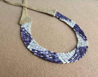 Wampum jewelry made by Aquinnah Wampanoag artist Elizabeth James-Perry. Image of the Alliance Collar courtesy of the artist. Purple and white beaded necklace