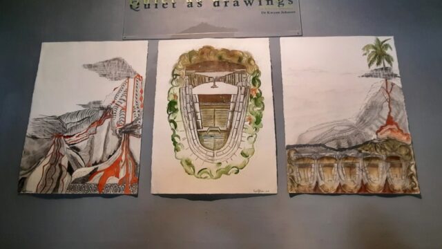 Installation of triptychs in Quiet as drawings exhibit. Photograph by David Cave, 2021. Three watercolor drawings placed on wall with sign saying quiet as drawings