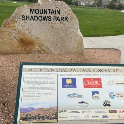 A plaque lists sponsors of the "Mountain Shadows Park Renovation". In the background, a rock is cared with "Mountain Shadows Park".